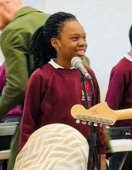 A pupil speaking into a microphone at a performance